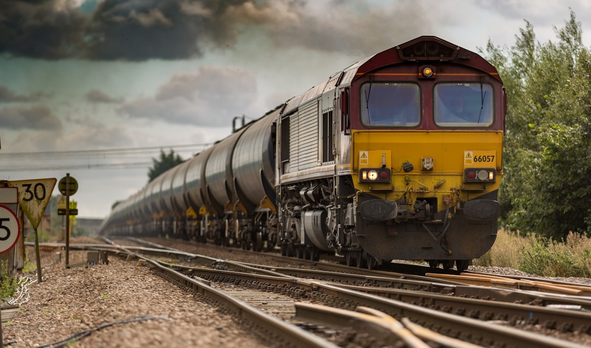 Cargo train running along railway tracks across countryside